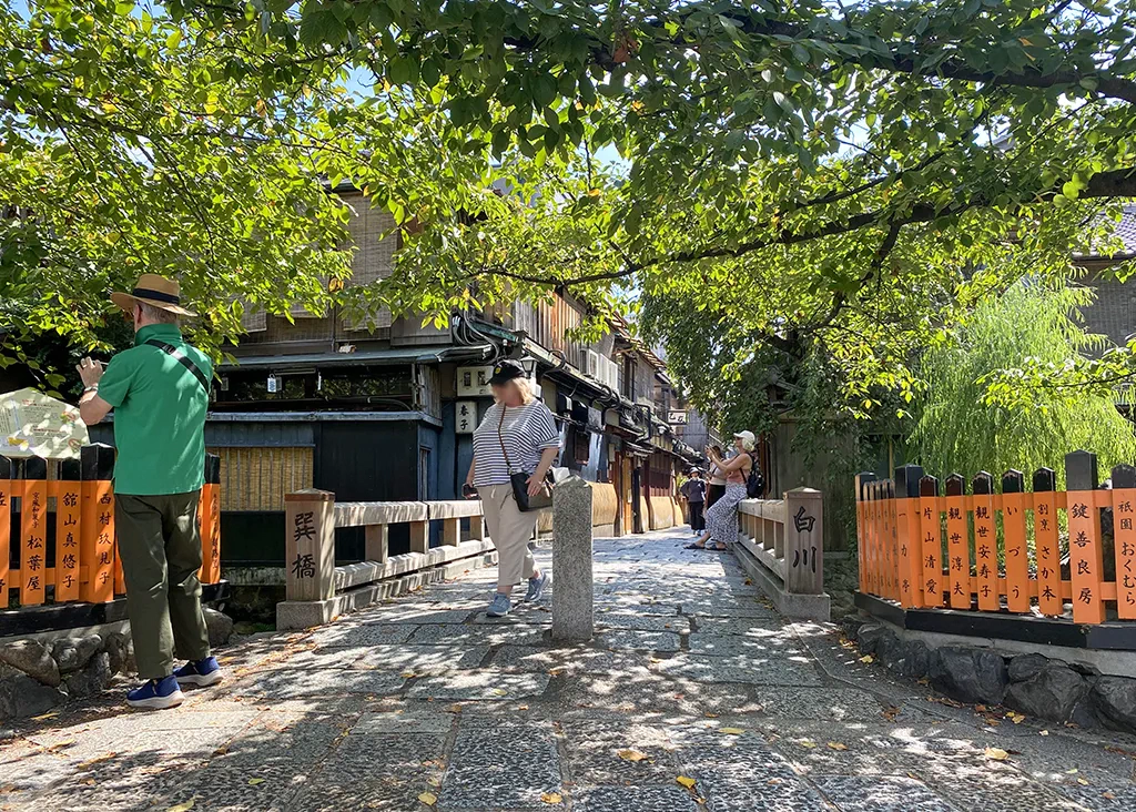 祇園白川の巽橋。外国人の観光客が写真を撮影している。