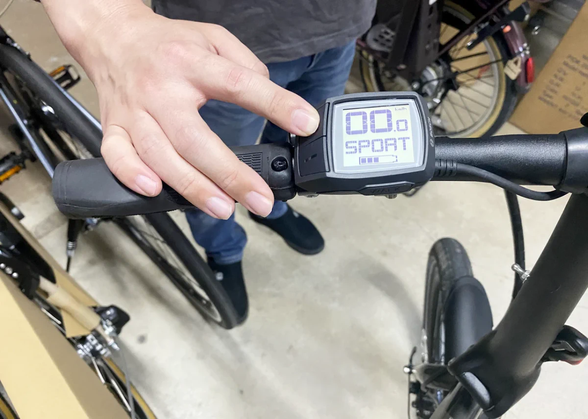 電動自転車VEKTRONの操作方法について説明しているスタッフの写真。