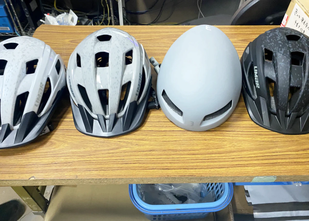 無料レンタルオプションの様々なタイプのヘルメットが机の上に並んでいる写真。