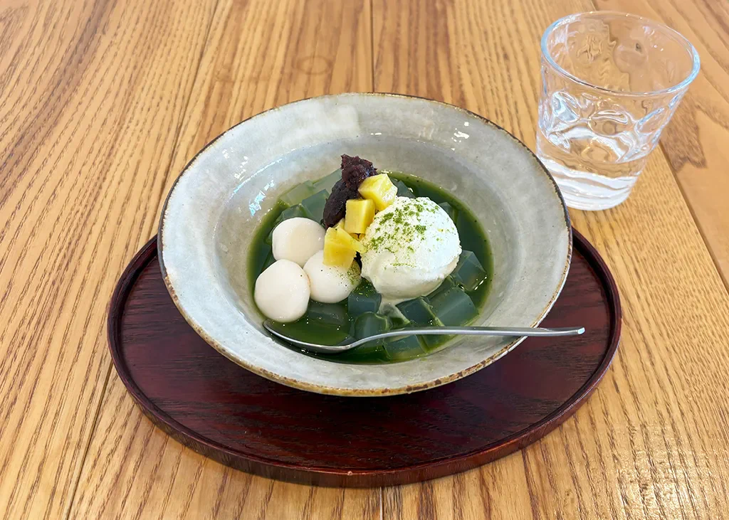 今回いただいたのは、抹茶あんみつ(アイスクリーム付き)。寒天ゼリーにつぶあんや白玉、甘く煮たさつまいもがのっている、甘くて冷たい和スイーツです。