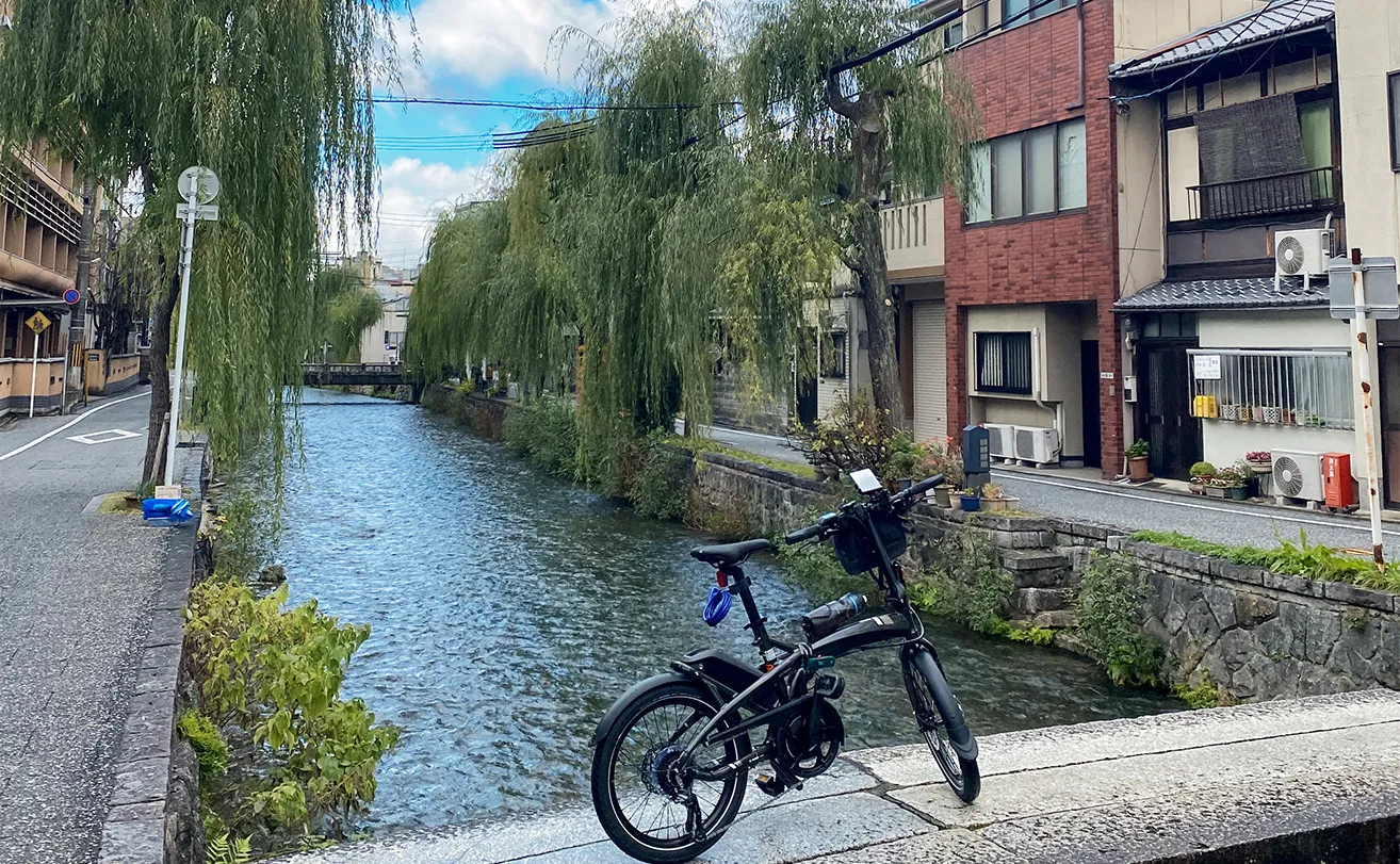 A Tern Vektron e-bike on a bridge overlooking a river in Kyoto.